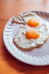 Fried eggs with salt and pepper on a plate