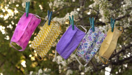 Covid-19 Pandemic. A reusable DIY fabric cotton mask is dried on a clothesline in the open air for...