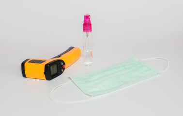 Health mask and infrared thermometer and alcohol spray bottle for the prevention or screening of plague Covid-19 isolated on a white background
