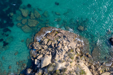 Aerial drone top-down view of calm turquoise water and rocks on the beautiful coast of Spain on the east side