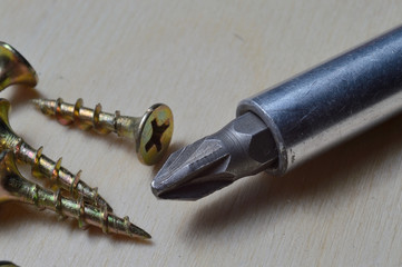 yellow screws and a screwdriver. close-up.