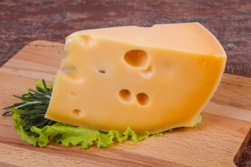 Maasdam cheese  in the board served salad leaves