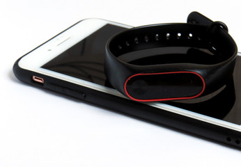 fitness watch (activity tracker). Fitness tracker lies on the smartphone and tablet. Selective focus