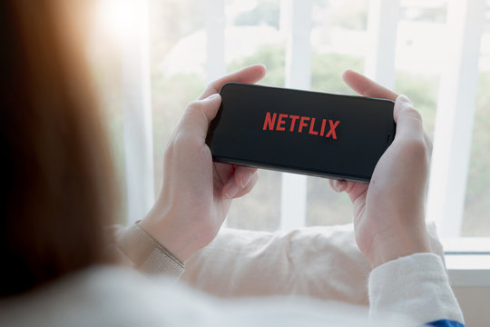 CHIANG MAI, THAILAND, APR 06 , 2020: Woman hand holding Smart Phone with Netflix logo on Apple iPhone Xs. Netflix is a global provider of streaming movies and TV series.