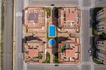 Aerial drone top-down photo of a vacation city in Spain with pools and urban buildings