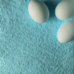 White eggs on paper background, copy space.