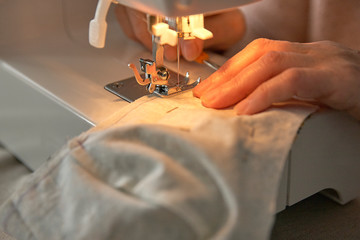 Detail shot of hands sewing a face mask .