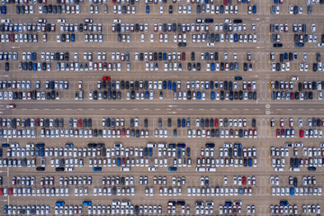 Aerial top down photo of a massive symmetrical parking lot with maximum white coloured cars