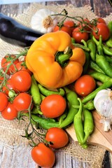 Fototapeta na wymiar ortaggi freschi melanzane peperoni peperoncini verdi pomodori caglio cibo vegetariano