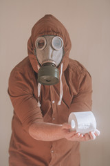 A man in a protective gas mask with toilet paper in his hands.