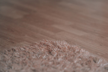 Carpet on the floor. Abstract defocused background with a long pile carpet on the laminate.