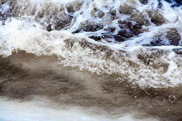 Cold water, waves with foam. Beautiful sea background with wave and blue water in winter.