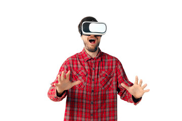 Young caucasian man emotional playing, using virtual reality headset isolated on white studio background. Concept of modern technologies, gadgets, tech, human emotions, advertising. Copyspace. AR, VR.