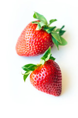 Two fresh strawberries were placed on a white background