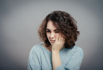 Beautiful sad casual lady isolated on gray background