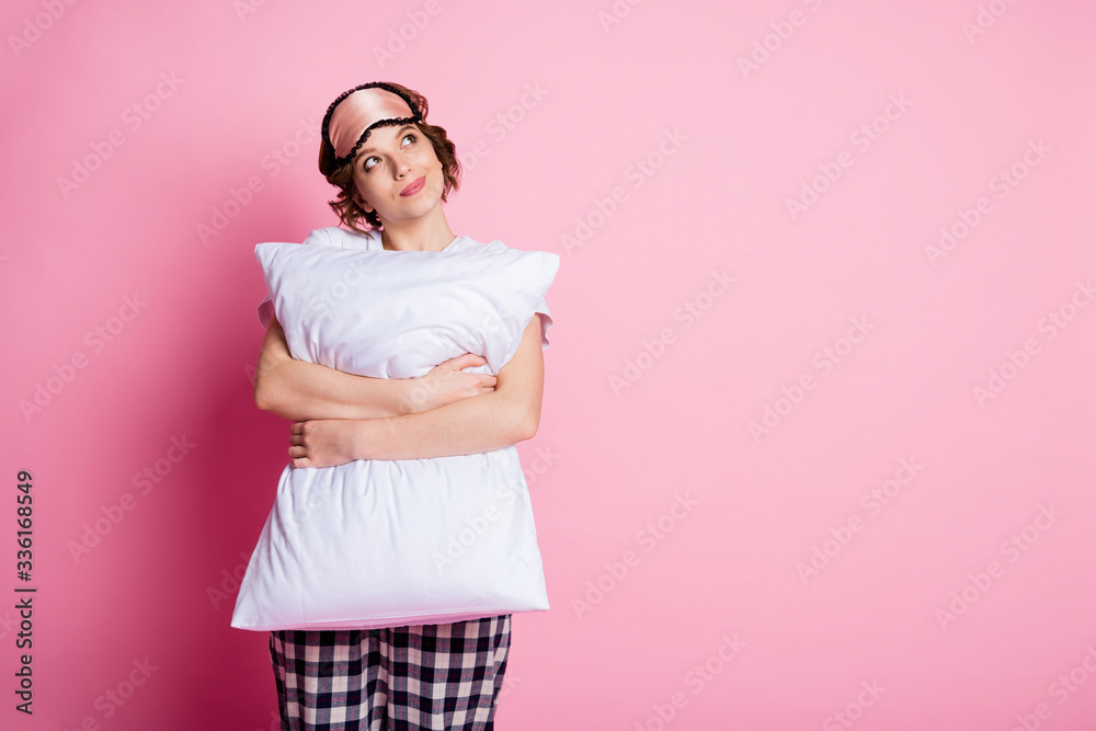 Poster Photo of pretty dreamer lady hold hug pillow look up empty space dreamy mood wear sleep mask white t-shirt checkered pajama pants isolated pink color background