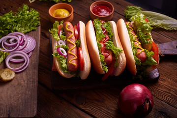 Hot dogs. Grilled hot dogs with mustard and ketchup on a picnic wooden table. Sandwich