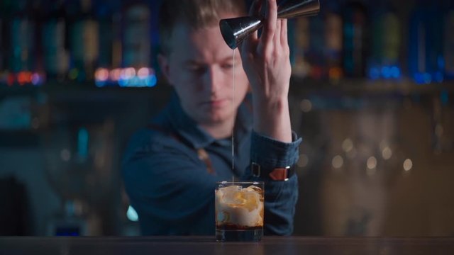 bartender preparing white russian cocktail in night club