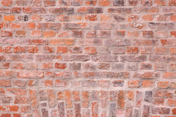 Surface of red brick wall, with some aged cracks in bricks structure
