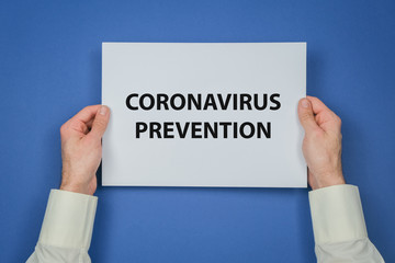 Mans hand hold a sheet of paper with Corona Virus prevention steps.