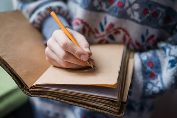 Human hands with pencil writing on paper