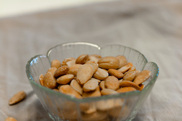 Bowl of  toasted almonds on a gray background
