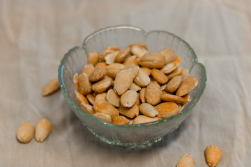 Bowl of  toasted almonds on a gray background