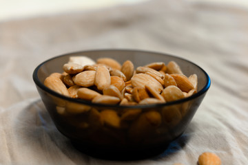 Bowl of  toasted almonds on a gray background