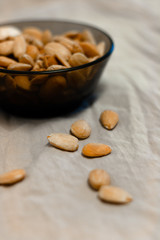 Bowl of  toasted almonds on a gray background