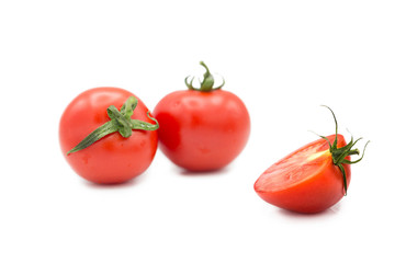 Ripe fresh organic tomatoes and half a tomato in the drops of dew isolated on a white background