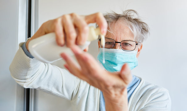 Seniorin macht flüssige Seife auf Hände wegen Coronavirus