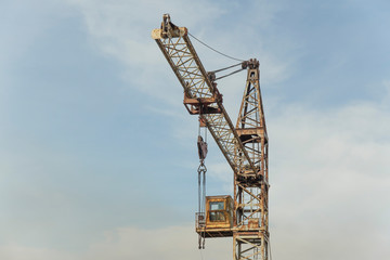 Fototapeta na wymiar old abandoned soviet rusty crane with tower on sky background 