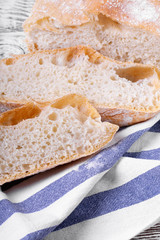 Freshly baked wheat bread cut into slices on the cotton towel