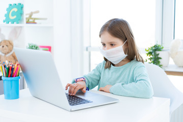 Cute little girl studying at home during quarantine