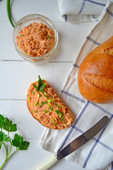 Fish pate with fresh bread on a white kitchen table.