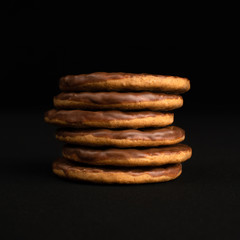 Stack of chocolate digestive biscuits isolated on a black background