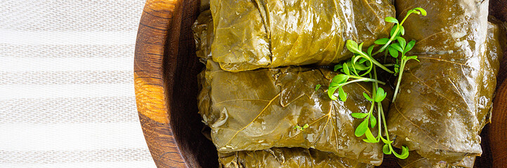 dolma (sarma) stuffed grape leaves on wooden plate