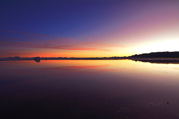 Piękny zachód słońca nad jedną z lagun położonych na wielkim solnisku w Uyuni - Boliwia - obrazy, fototapety, plakaty