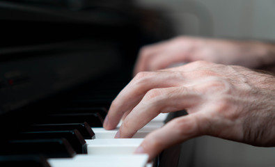 hands of a man playing the piano during the day, stylish photo