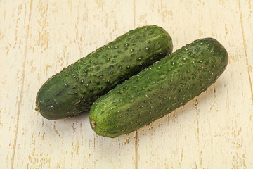 Green fresh cucumbers over background