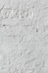 The brick wall is whitewashed, cracked old.