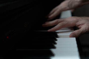 hands of a man playing the piano during the day, stylish photo