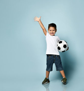 Cute boy playing football, happy child, young male teen goalkeeper enjoying sport game, holding ball, isolated portrait of a preteen smiling and having fun