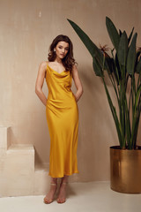 Pretty beautiful woman brunette hair natural makeup wear fashion clothes yellow silk long dress...