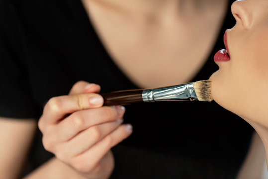 Cropped View Of Young Makeup Artist Applying Concealer On Model