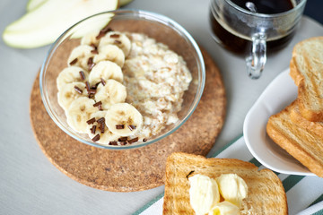 freshly cooked porridge with banana and toasts with butter