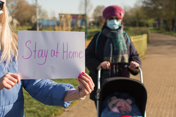 family at the park on quarantine with stay at home sign