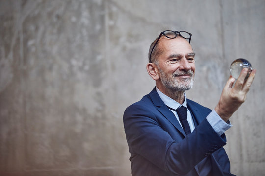 Senior businessman looking at crystal ball