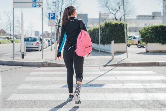 Sporty young woman with leg prosthesis walking in the city