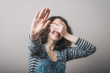 Happy girl shows five fingers, and covers his face